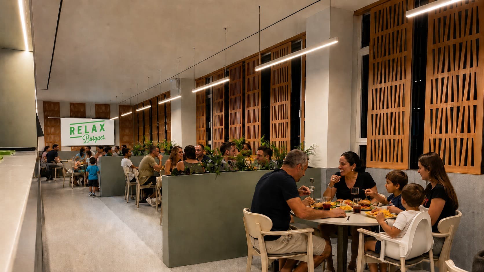 Sala do Relax Burguer com famílias e clientes à mesa, e o logótipo projetado na parede